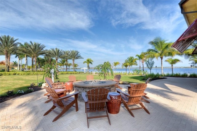 view of patio / terrace with a fire pit and a water view