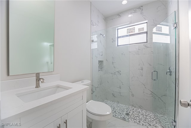 bathroom with vanity, toilet, and a shower with shower door