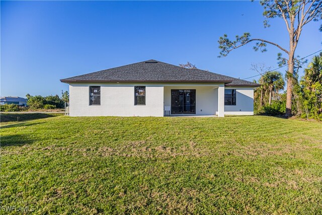 rear view of house featuring a lawn