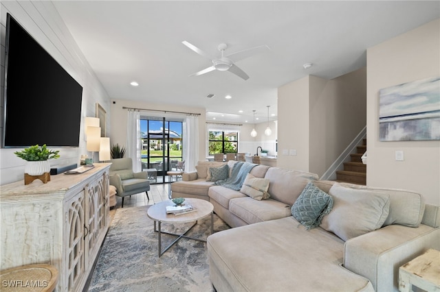 living room with wood-type flooring and ceiling fan