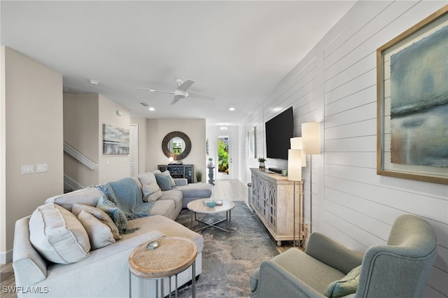 living room featuring wood walls and ceiling fan