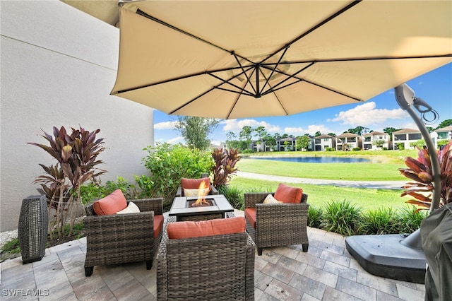 view of patio / terrace with a fire pit and a water view