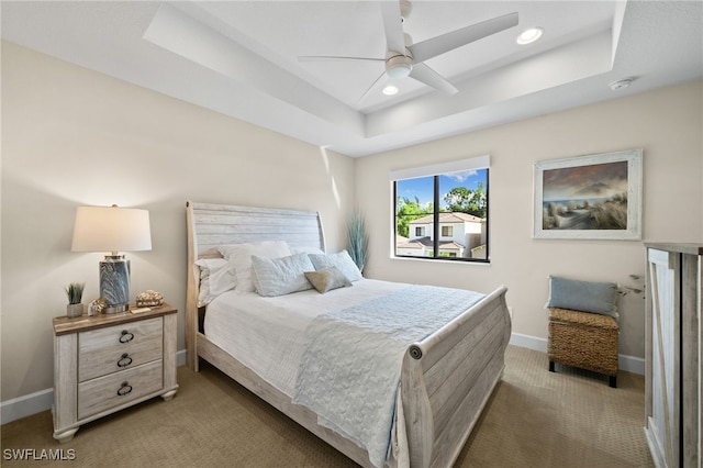 bedroom with carpet, ceiling fan, and a raised ceiling