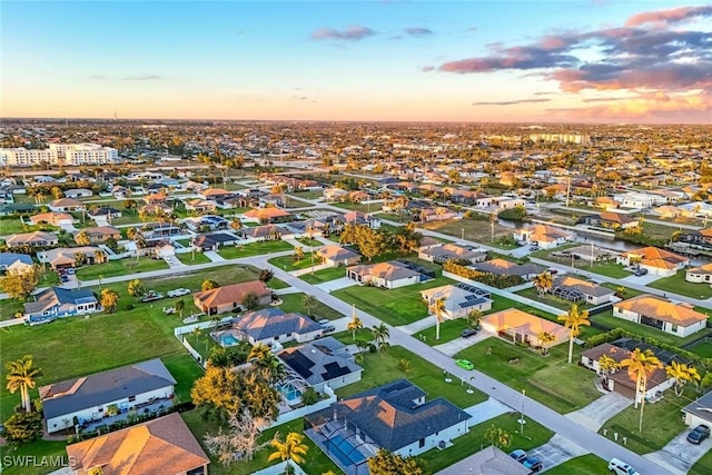 aerial view at dusk featuring a residential view