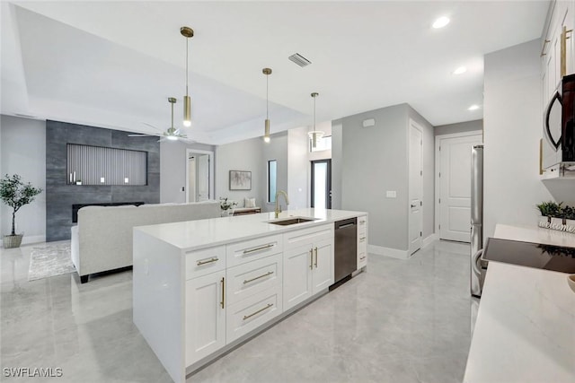 kitchen with recessed lighting, a sink, baseboards, white cabinets, and appliances with stainless steel finishes