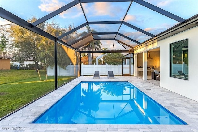 view of pool with a fenced in pool, a lawn, a patio, glass enclosure, and fence