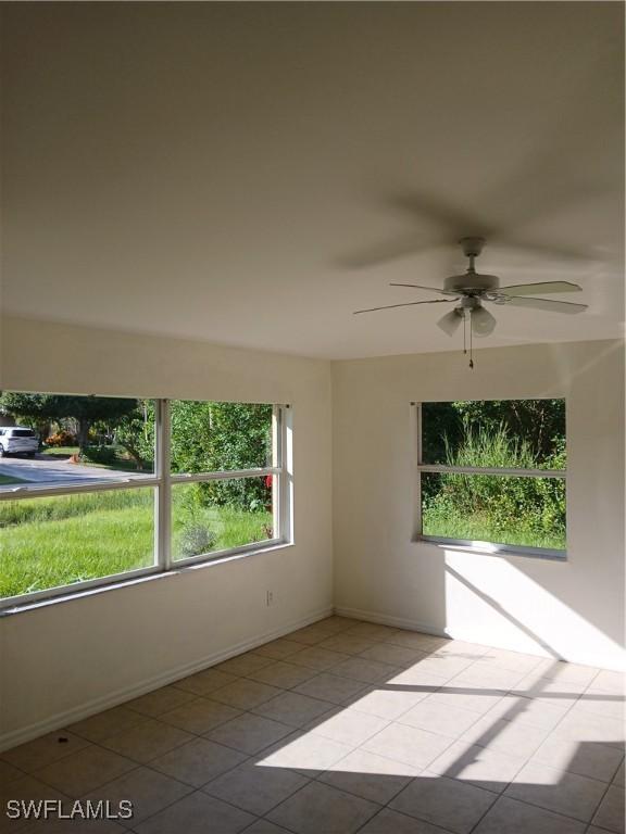 empty room featuring ceiling fan and light tile patterned floors