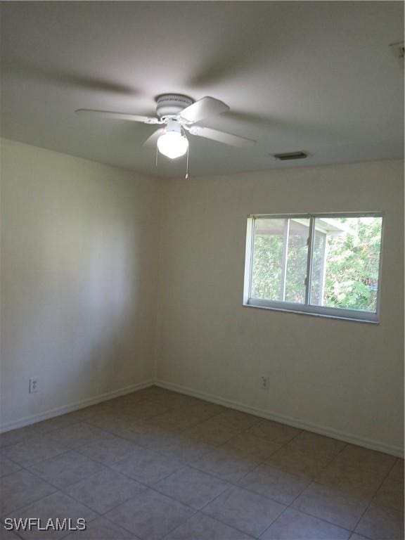 tiled spare room featuring ceiling fan