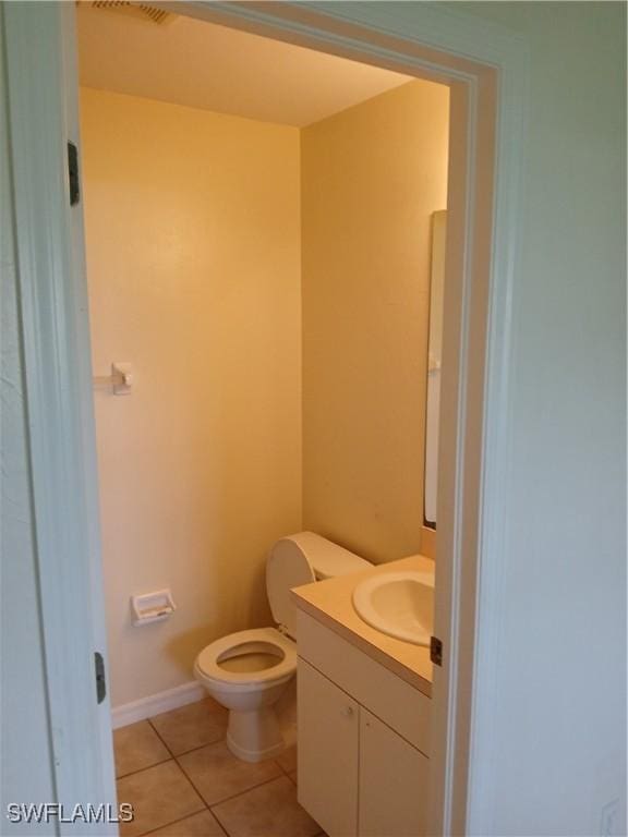 bathroom with tile patterned flooring, vanity, and toilet