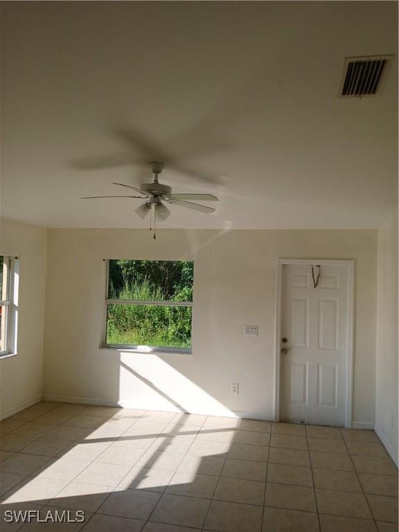 tiled spare room with ceiling fan