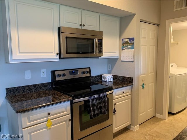 kitchen featuring visible vents, stainless steel appliances, washer / dryer, and white cabinetry