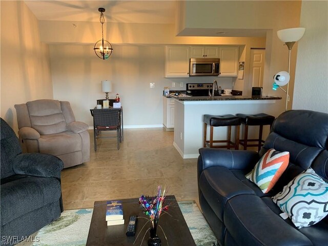 tiled living room with a notable chandelier