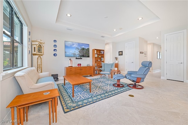 tiled living room featuring a tray ceiling