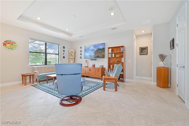 living area featuring visible vents, baseboards, a raised ceiling, and recessed lighting