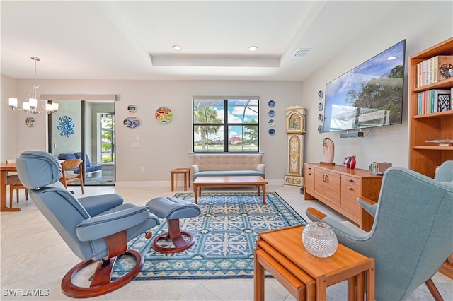 living room featuring light tile patterned floors, a raised ceiling, and a notable chandelier