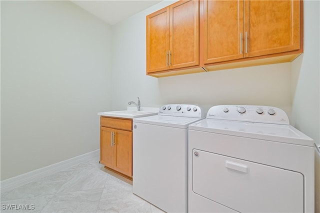 clothes washing area featuring independent washer and dryer, a sink, cabinet space, and baseboards