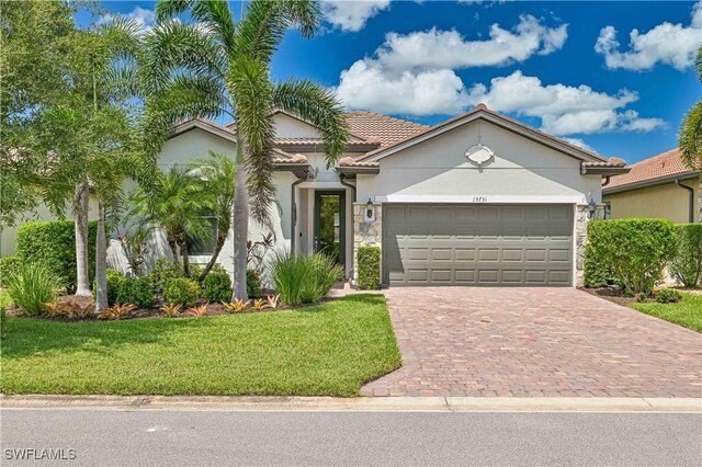 view of front of property with a front yard and a garage