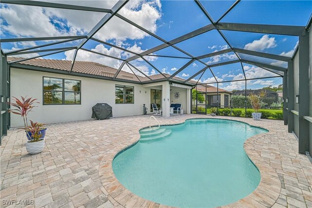 view of swimming pool featuring a lanai, area for grilling, and a patio