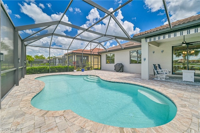 view of swimming pool featuring a patio area, ceiling fan, and a lanai