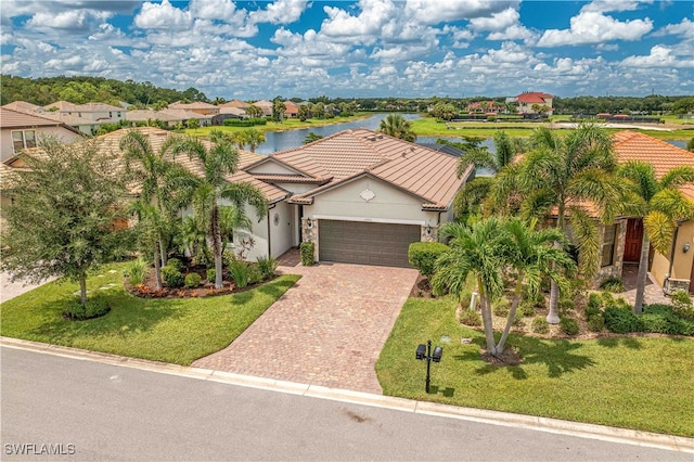 view of front facade with a water view, a garage, and a front yard