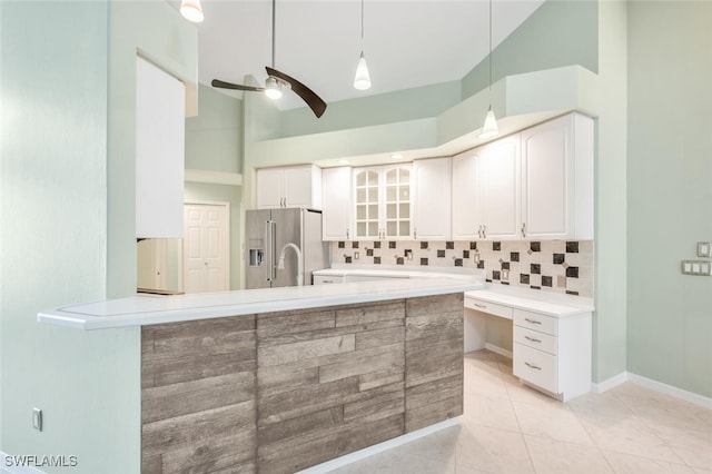 kitchen featuring high vaulted ceiling, white cabinetry, high end refrigerator, and hanging light fixtures