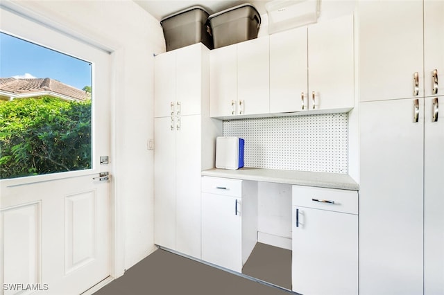 interior space featuring white cabinets and backsplash