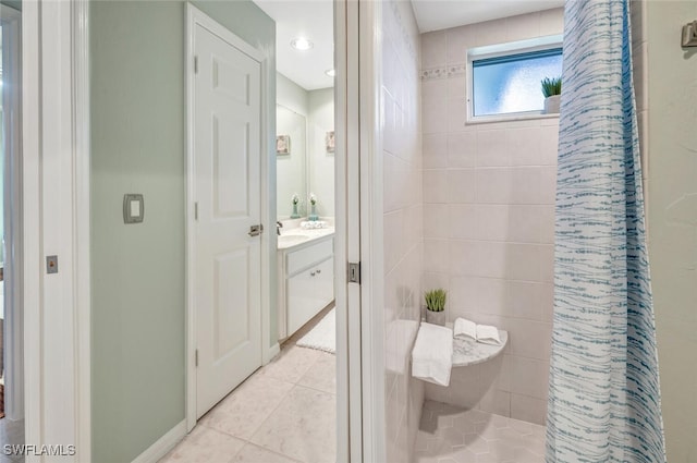 bathroom featuring vanity, tile patterned floors, and a tile shower