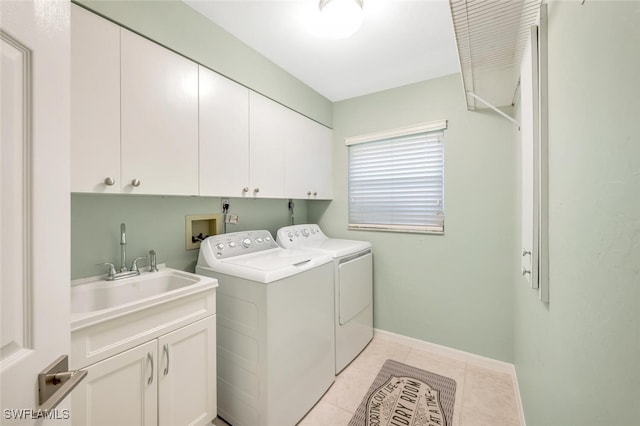 laundry area featuring cabinets, light tile patterned flooring, sink, and washing machine and clothes dryer