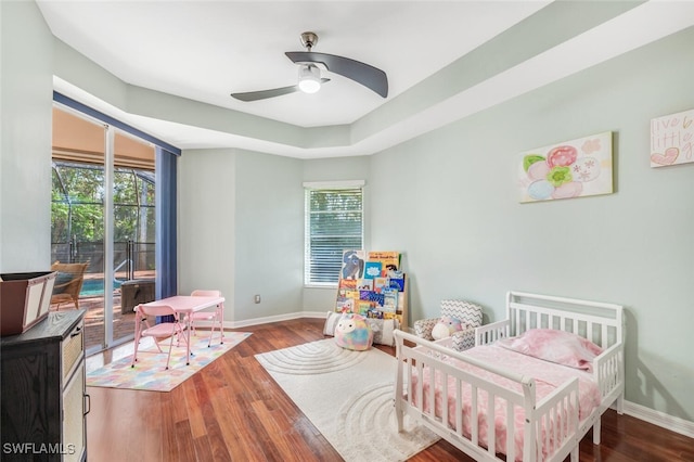 bedroom with ceiling fan, wood-type flooring, and multiple windows