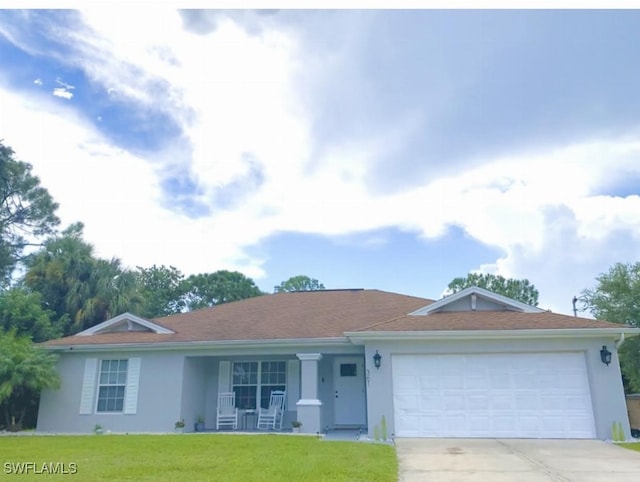 single story home featuring a garage, a front yard, and covered porch