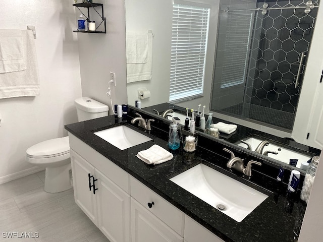 bathroom with tile patterned floors, toilet, an enclosed shower, and vanity