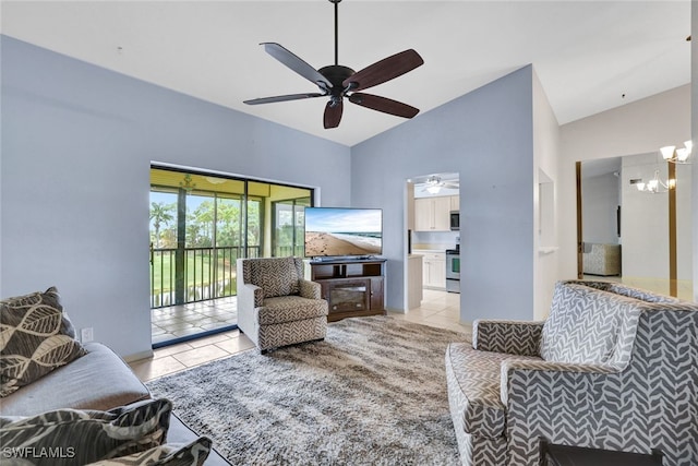 tiled living room featuring ceiling fan with notable chandelier and high vaulted ceiling