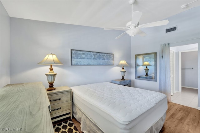 bedroom with ceiling fan, a closet, and light hardwood / wood-style floors