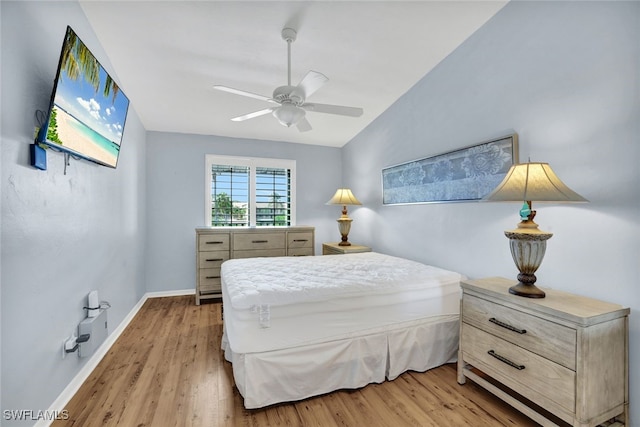 bedroom featuring ceiling fan, light hardwood / wood-style flooring, and vaulted ceiling