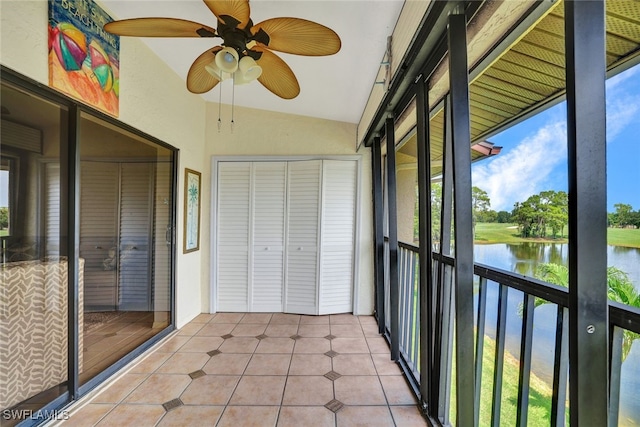 unfurnished sunroom featuring ceiling fan, lofted ceiling, and a water view