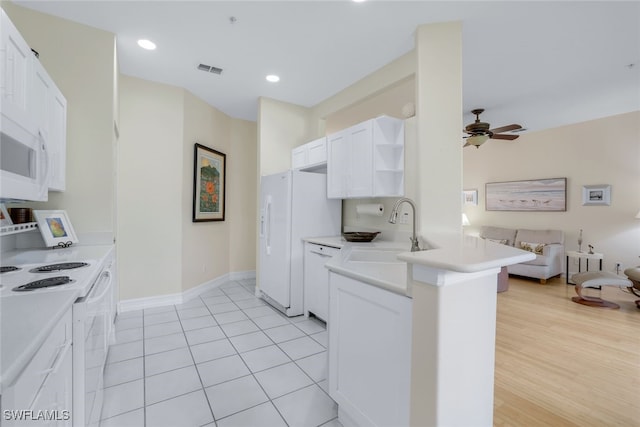 kitchen with white appliances, a ceiling fan, open floor plan, white cabinetry, and a sink