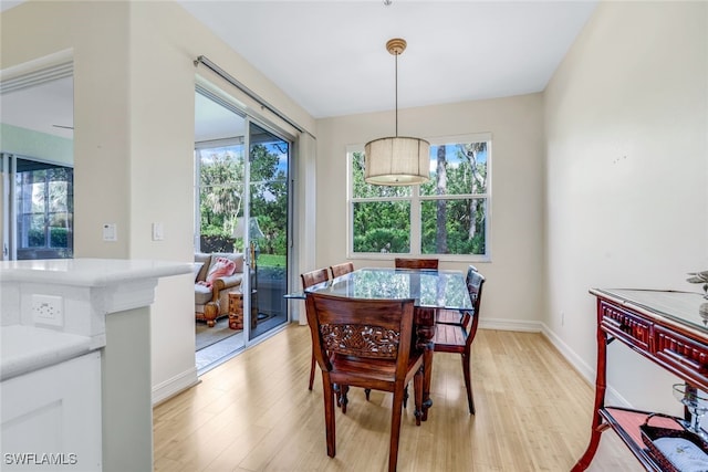 dining room featuring light wood-style flooring and baseboards