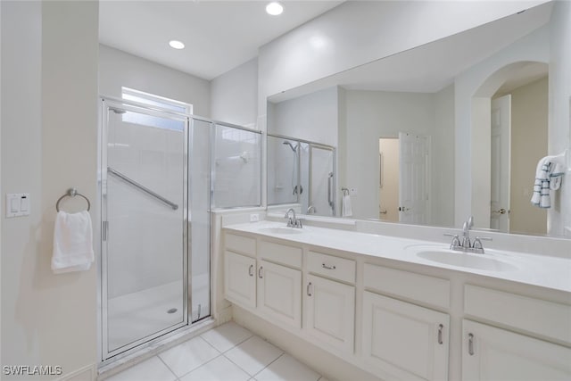 bathroom with a stall shower, tile patterned flooring, and a sink