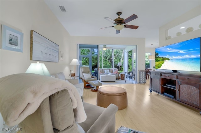 living area with a ceiling fan, visible vents, and wood finished floors