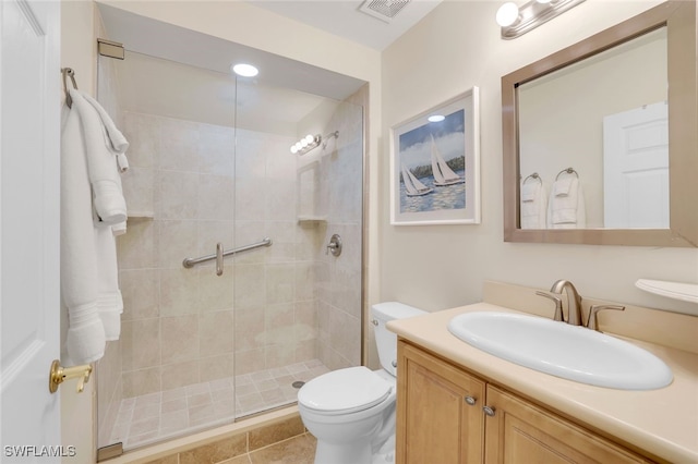 bathroom with visible vents, vanity, a shower stall, and toilet