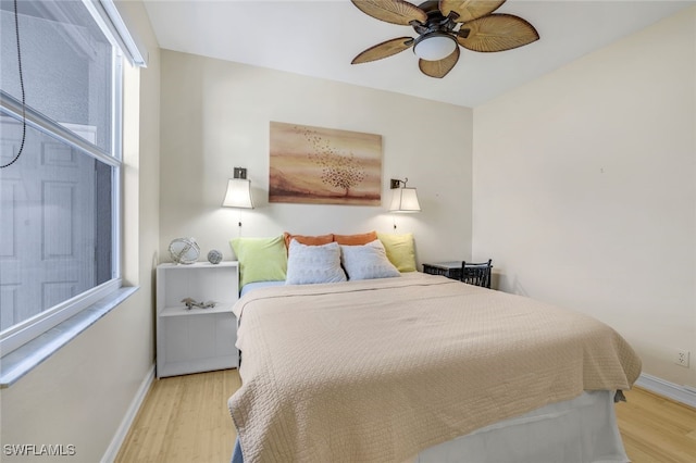 bedroom featuring light wood-style floors, baseboards, and a ceiling fan