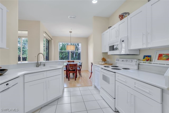 kitchen featuring white appliances, a sink, visible vents, white cabinets, and light countertops