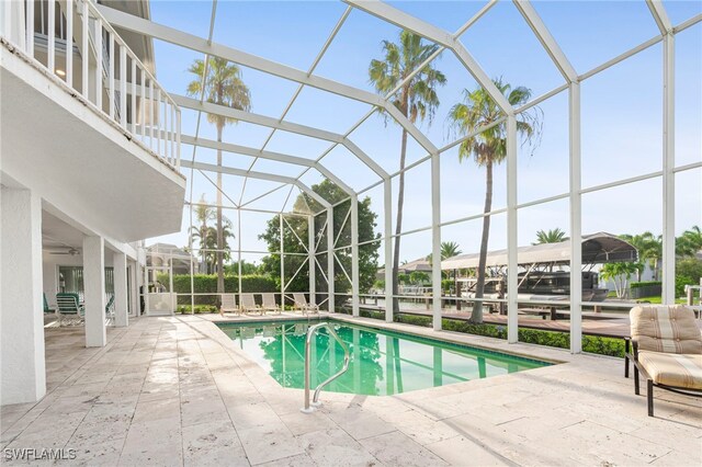 view of pool with a patio area and glass enclosure