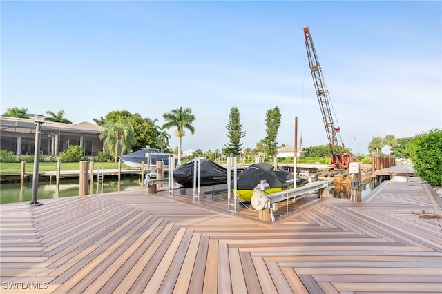 wooden terrace featuring a dock, a water view, and boat lift