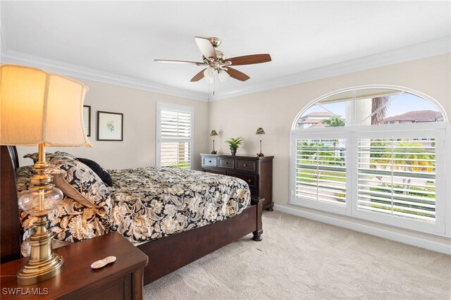 carpeted bedroom featuring ceiling fan and crown molding