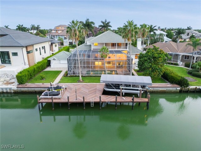 back of property featuring a yard, a water view, and a lanai