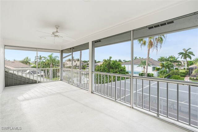 unfurnished sunroom with ceiling fan