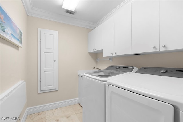 laundry area with washing machine and clothes dryer, cabinets, ornamental molding, and light tile patterned floors