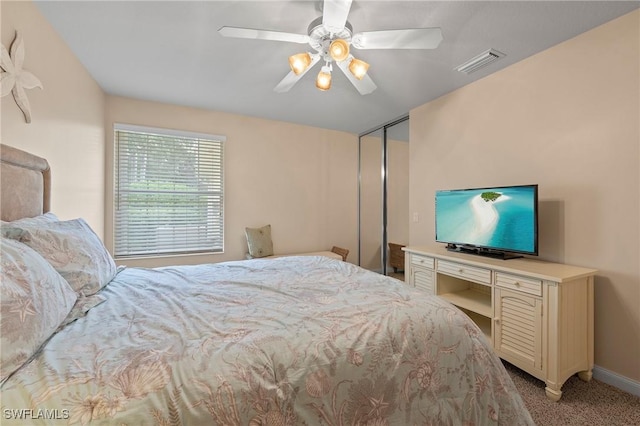 bedroom with baseboards, a ceiling fan, visible vents, and light colored carpet