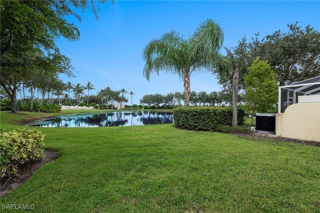 view of yard with glass enclosure and a water view